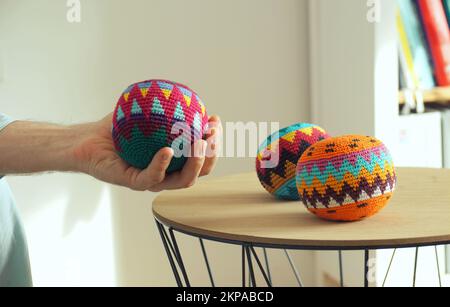 Primo piano di tre diverse palline da giocoleria colorate su un tavolo di legno Foto Stock