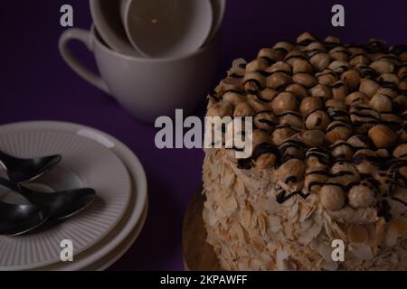 foto torta di noce rotonda con piatti tazze piattini cucchiai Foto Stock