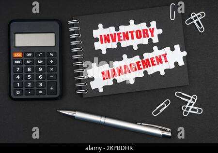 Business ed Economia. Sulla tabella sono riportati una calcolatrice, una penna e un notebook con l'iscrizione Inventory Management Foto Stock