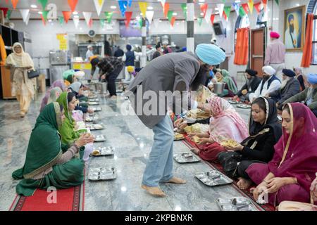 LANGAR. I volontari di un tempio Sikh distribuiscono cibo vegetariano a adoratori e visitatori. In un tempio di Richmond Hill, Queens, New York City. Foto Stock