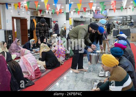 LANGAR. I volontari di un tempio Sikh distribuiscono cibo vegetariano a adoratori e visitatori. In un tempio di Richmond Hill, Queens, New York City. Foto Stock