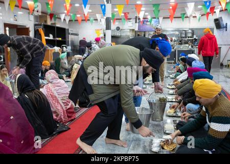 LANGAR. I volontari di un tempio Sikh distribuiscono cibo vegetariano a adoratori e visitatori. In un tempio di Richmond Hill, Queens, New York City. Foto Stock