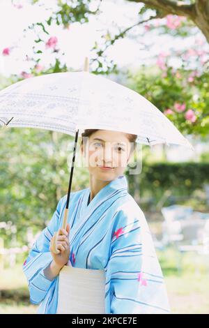 Donna giapponese in uno yukata con un ombrellone Foto Stock