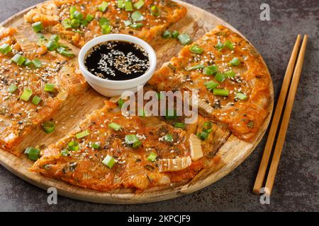 Kimchi-buchimgae o kimchijeon fatto con kimchi affettati, pastella di farina e a volte altri ortaggi primo piano sul legno tavola. Horizont Foto Stock