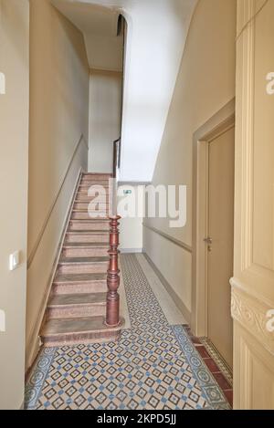 Porta d'ingresso e scale di legno arrugginite nella scala del palazzo Foto Stock