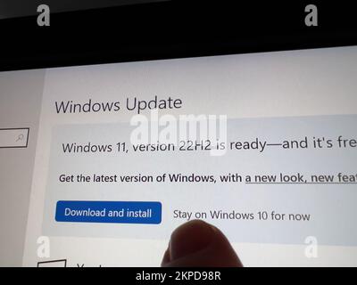 Parigi, Francia - 5 ottobre 2022: POV dito maschio che mostra al touch-screen di un display - Windows Update Windows 11 versione 22h2 è pronto per essere scaricato - installare o rimanere su Windows 10 ora Foto Stock