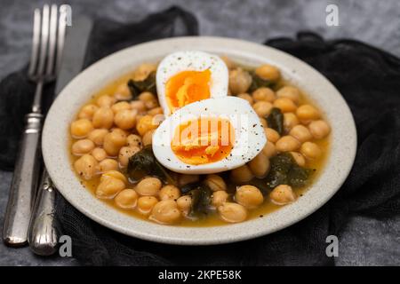 Ceci bolliti con spinaci e uova bollite su piatto piccolo Foto Stock