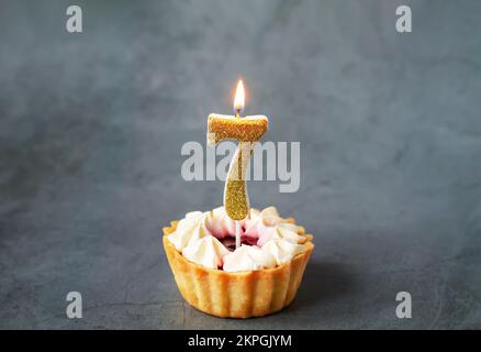 Numero sette candela di compleanno bruciante su gustoso cupcake Foto Stock