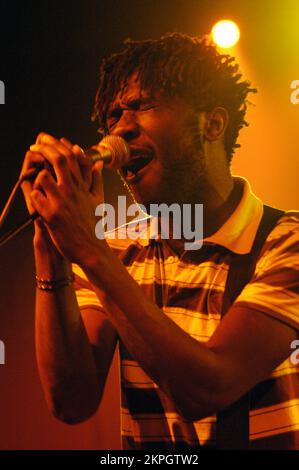 BLOC PARTY, SILENT ALARM TOUR, 2005: A Young Kele Okereke from Bloc Party on the NME Tour at Cardiff University, 6 febbraio 2005. Fotografia: ROB WATKINS. INFO: Bloc Party è un gruppo musicale indie rock britannico formatosi nel 1999. Noti per il loro suono energico e i testi perspicaci, hanno guadagnato importanza con il loro album di debutto "Silent Alarm". Lo stile dinamico della band fonde influenze post-punk, elettroniche e alternative rock. Foto Stock