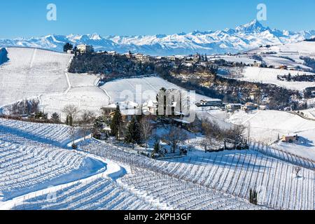 Case sulle colline tra vigneti ricoperti di neve in Piemonte, nel Nord Italia. Foto Stock