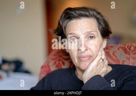 Donna anziana triste da sola in una camera d'albergo Foto Stock