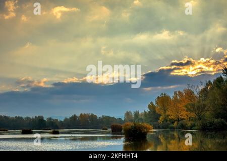 Alba sul lago, sole nascosto dietro una nuvola. Paesaggio autunnale. Dubnica, Slovacchia. Foto Stock