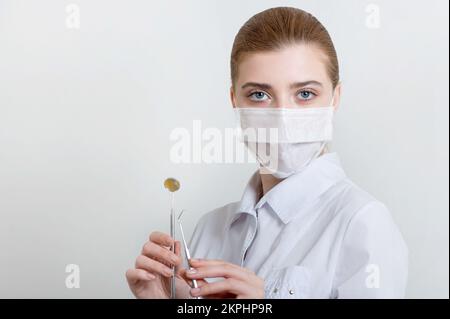 Giovane medico dentista con strumenti odontoiatrici. Riprese in studio. Foto Stock