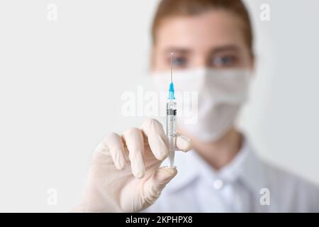 Mano del medico con la siringa per iniezione in mano. Primo piano, messa a fuoco selettiva. Foto Stock