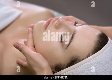 Il massaggio del viso. Spa la cura della pelle e del corpo. Close-up di giovane donna getting spa massaggio a beauty spa salone. Bellezza del Viso Trattamento. Foto Stock