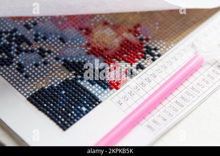 Tele diamantate e Fixer manuale per il processo di creazione artigianale di pittura diamantata 3D da rhinestones multicolori quadrati Foto Stock