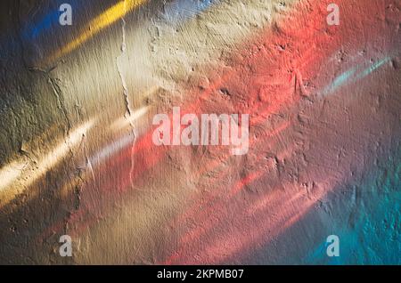 Raggi di luce colorati da una finestra di vetro colorato che splende su una parete della chiesa Foto Stock