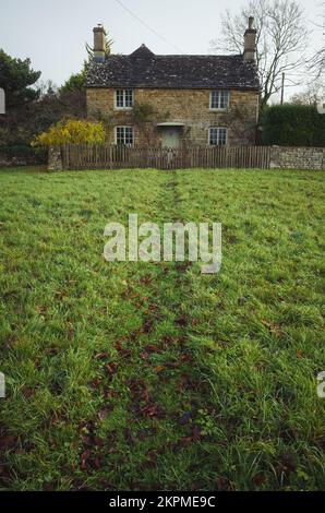 Cottage in pietra Cotswold con un percorso in erba a Wyck Rissington, Gloucestershire, Regno Unito Foto Stock