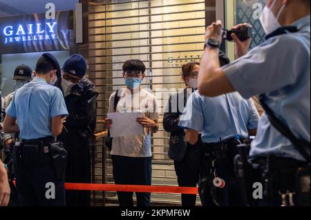 Hong Kong. 28th Nov 2022. Gli agenti di polizia interrogano e registrano i dati personali dei manifestanti durante la manifestazione. Decine di persone si sono riunite in solidarietà con coloro che in Cina si sono mobiliti contro le politiche zero-COVID del governo. Poco dopo aver cantato 'non volere l'autoritarismo, non volere una monarchia', Wong è stato attaccato da un assalitore e bussato a terra. Credit: SOPA Images Limited/Alamy Live News Foto Stock