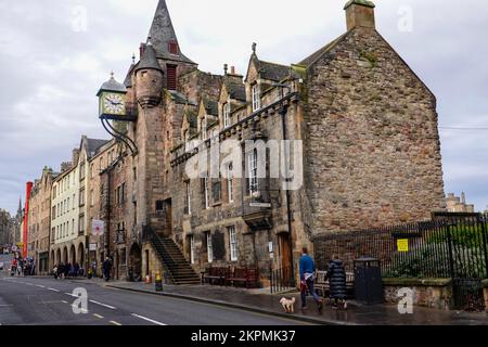 Persone che camminano lungo il marciapiede del Royal Mile nella zona di Canongate, di fronte agli interessanti edifici che contengono la Tavern Tolbooth, Edinburgo. Foto Stock