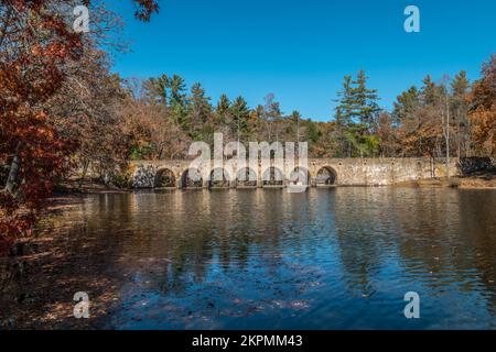 Una vista pittoresca in autunno del ponte di pietra a sette archi che attraversa un lago nel parco statale del Tennessee in una giornata di sole Foto Stock