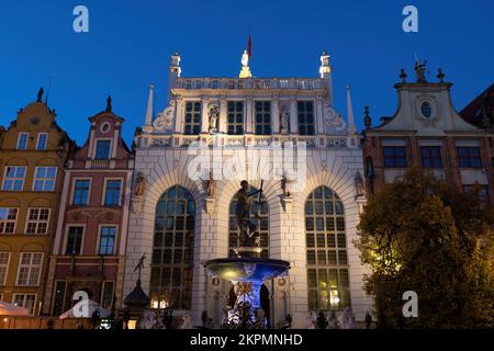 La Corte di Artus e la Fontana di Nettuno di notte nella città di Danzica in Polonia. Foto Stock