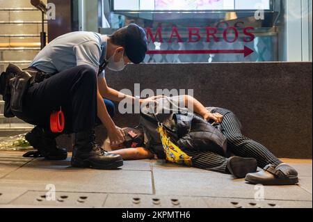 Hong Kong. 28th Nov 2022. La nonna Wong è frequentata da un ufficiale di polizia dopo essere stata abbattuta a terra da un assalitore durante una dimostrazione. Decine di persone si sono riunite in solidarietà con coloro che in Cina si sono mobiliti contro le politiche zero-COVID del governo. Poco dopo aver cantato 'non volere l'autoritarismo, non volere una monarchia', Wong è stato attaccato da un assalitore e bussato a terra. (Foto di ben Marans/SOPA Images/Sipa USA) Credit: Sipa USA/Alamy Live News Foto Stock