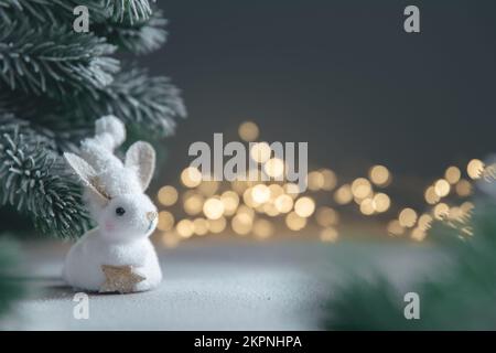 Un coniglio simbolo di 2023 tra le luci, ghirlande, alberi di Natale, calendario cinese anno simbolo con spazio copia Foto Stock