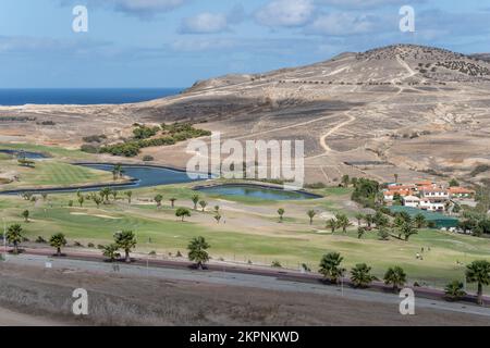 Paesaggio con laghi di verde campo da golf tra pendii aridi, girato in luce brillante autunno a Porto Santo isola, Portogallo Foto Stock