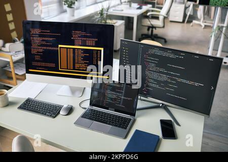 Computer e laptop sulla scrivania dell'ufficio dello sviluppatore di software Foto Stock