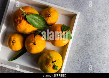 Vista dall'alto di una scatola di legno riempita di arance mature Foto Stock