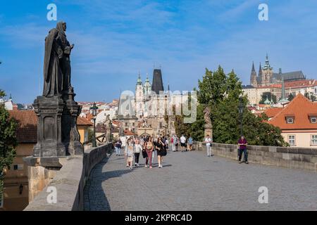 Praga, Repubblica Ceca - 5 settembre 2022: Persone che camminano sul Ponte Carlo, con la torre del Ponte Vecchio sullo sfondo Foto Stock