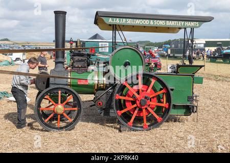 Tarrant Hinton.Dorset.United Kingdom.August 25th 2022.A replica di un motore di trazione Wallis e Steevens costruito nel 1980s è alla guida di un mac di trebbiatura Foto Stock