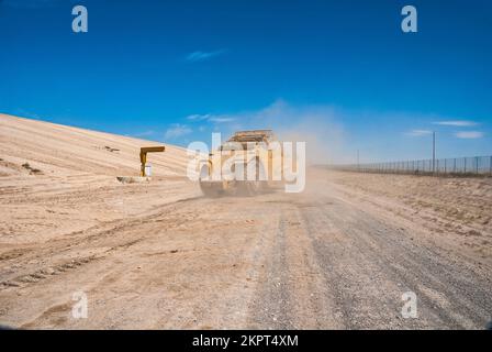 Attrezzature pesanti Caterpillar che lavorano in discarica attiva in condizioni polverose e sporche. Foto Stock