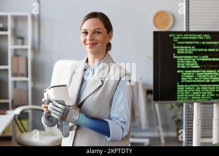 Ritratto di un ricercatore sorridente con braccio protesico che tiene occhiali VR Foto Stock