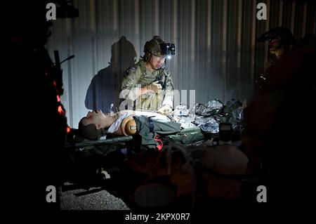 Un membro del team Special Operations Surgical del 24th Special Operations Wing tratta le vittime simulate di notte durante un esercizio congiunto Special Operations Forces del 3 novembre 2022 presso Eglin Air Force Range, Fla. I SOST sono chirurghi sul campo di battaglia pronti per il combattimento e personale di supporto medico che hanno portato una pletora di abilità avanzate di medicina di combattimento all'impresa USSOF. Foto Stock