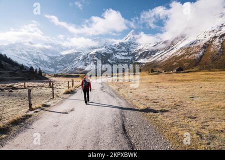 Vista posteriore di una donna che cammina lungo un sentiero alpino verso le montagne, Gastein, Salisburgo, Austria Foto Stock