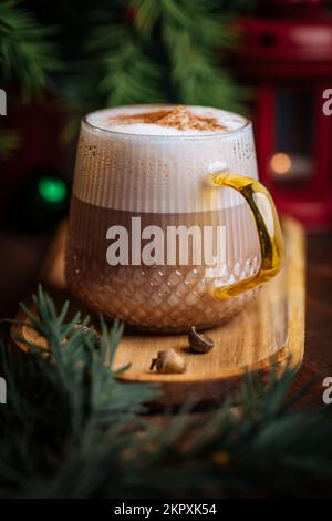 Tazza di vetro di zucca speziata tardi o di melone in un'atmosfera festosa, accogliente e di Natale inverno. Sensazione di umore a casa. Foto Stock