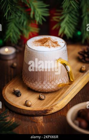 Tazza di vetro di zucca speziata tardi o di melone in un'atmosfera festosa, accogliente e di Natale inverno. Sensazione di umore a casa. Foto Stock