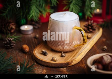 Tazza di vetro di zucca speziata tardi o di melone in un'atmosfera festosa, accogliente e di Natale inverno. Sensazione di umore a casa. Foto Stock