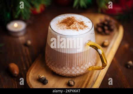 Tazza di vetro di zucca speziata tardi o di melone in un'atmosfera festosa, accogliente e di Natale inverno. Sensazione di umore a casa. Foto Stock