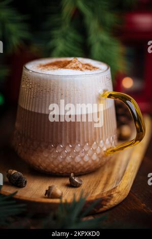 Tazza di vetro di zucca speziata tardi o di melone in un'atmosfera festosa, accogliente e di Natale inverno. Sensazione di umore a casa. Foto Stock