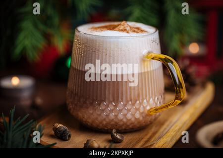 Tazza di vetro di zucca speziata tardi o di melone in un'atmosfera festosa, accogliente e di Natale inverno. Sensazione di umore a casa. Foto Stock