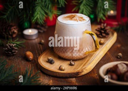 Tazza di vetro di zucca speziata tardi o di melone in un'atmosfera festosa, accogliente e di Natale inverno. Sensazione di umore a casa. Foto Stock