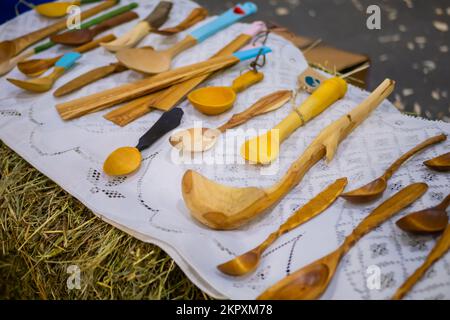 Cucchiai di legno intagliato fatti a mano, utensili da cucina sul banco della fiera Foto Stock