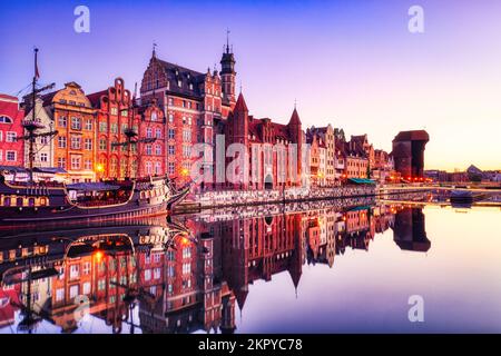 Illuminata la città vecchia di Danzica con il tranquillo fiume Motlawa all'alba, Polonia Foto Stock