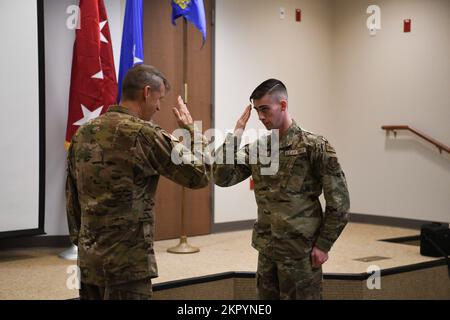 Il generale dell'esercito Daniel R. Hokanson, capo del National Guard Bureau, scambia un saluto con l'Airman 1st Class Kenneth Regis, membro del 106th Rescue Wing Maintenance Group della New York Air National Guard, dopo averlo presentato con una moneta di sfida durante una visita all'ala di F.S. Base della Guardia Nazionale aerea di Gabreski a Westhampton Beach, New York, il 5 novembre 2022. I 106th Rescue Wing Airmen sono addestrati per condurre missioni di ricerca e salvataggio in ambienti di combattimento. Foto Stock