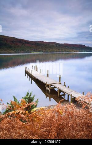 Molo in legno su un lago in autunno. Coniston Water, Lake District, Inghilterra, Regno Unito Foto Stock