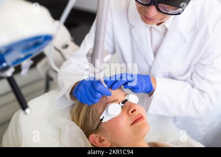 Donna che ottiene il trattamento facciale del laser nell'ufficio di medicina estetica Foto Stock