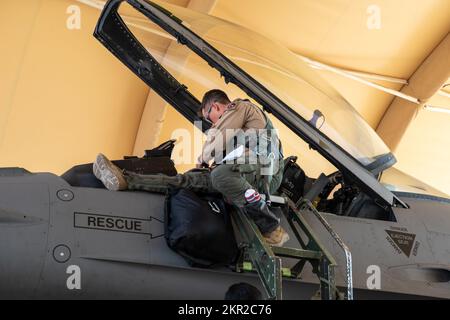 STATI UNITI Christopher Hartman, un pilota assegnato al 77th Expeditionary Fighter Squadron, sale nella cabina di pilotaggio di un F-16 Fighting Falcon prima della partenza per il Bahrain International Airshow (BIAS) 22, dalla base aerea del Principe Sultan, Regno dell'Arabia Saudita, 6 novembre 2022. BIAS, un evento biennale, è un'opportunità per rafforzare le relazioni militari-militari con partner regionali e promuovere gli obiettivi di sicurezza nazionali negli Stati Uniti Area di responsabilità del comando centrale. Foto Stock